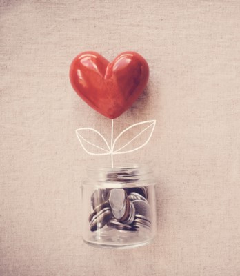 A jar of money with a chalk flower stem coming out of it leading to a heart.