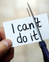Picture of a card that says "I Can't do it" being cut in half with scissors. 